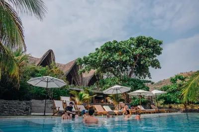a group of people sitting in the swimming pool at a resort at Puro Surf Hotel & Performance Academy in El Zonte