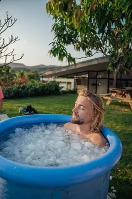 a man sitting in a tub of water at Puro Surf Hotel & Performance Academy in El Zonte
