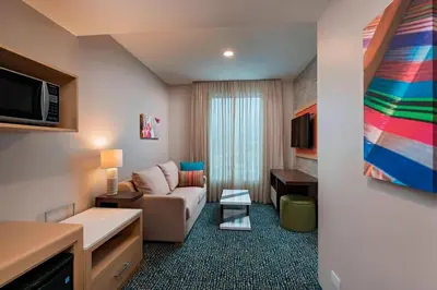 a hotel room with a couch and a tv at Fairfield by Marriott San Salvador in San Salvador