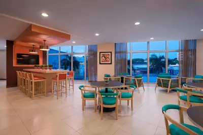 a restaurant with tables and chairs and a bar at Fairfield by Marriott San Salvador in San Salvador