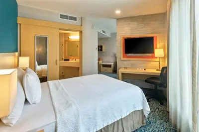 a hotel room with a bed and a desk and a television at Fairfield by Marriott San Salvador in San Salvador
