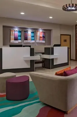 a living room with a couch and a tv at Fairfield by Marriott San Salvador in San Salvador