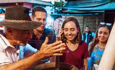a man wearing a hat talking to a woman at Hotel Juayua in Juayúa