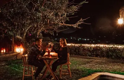 a man and woman sitting at a table at night at Hotel Juayua in Juayúa