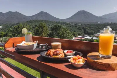 a tray of food on a table with a glass of orange juice at Hotel Juayua in Juayúa