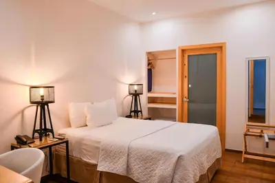 a bedroom with a white bed and two lamps at Kaleo Hotel Boutique in San Salvador