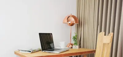 a laptop computer sitting on a wooden table with a lamp at Kaleo Hotel Boutique in San Salvador