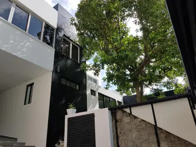 a black and white house with a tree at Kaleo Hotel Boutique in San Salvador
