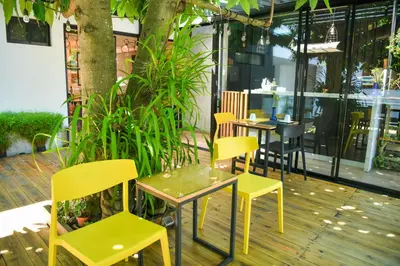 a restaurant with yellow chairs and tables on a deck at Kaleo Hotel Boutique in San Salvador