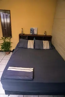 a large blue bed in a room with at Pool House Hostel in Santa Ana