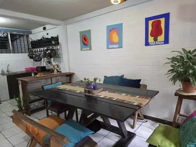 a dining room with a table and chairs at Pool House Hostel in Santa Ana