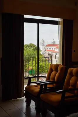 a room with a couch and a large window at Vista Los Volcanes Hotel y Restaurante in Juayúa