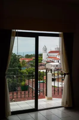an open window with a view of a building at Vista Los Volcanes Hotel y Restaurante in Juayúa