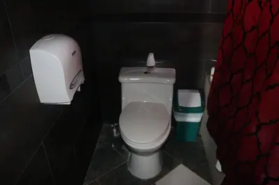 a bathroom with a toilet with a toilet paper dispenser at Vista Los Volcanes Hotel y Restaurante in Juayúa