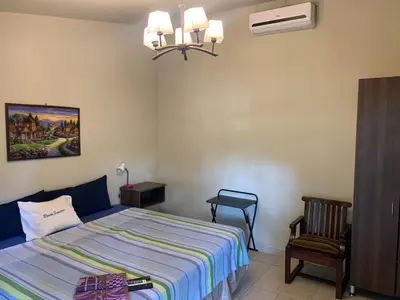 a bedroom with a bed and a chair in it at Hotel y Restaurante Rincón Familiar in La Libertad