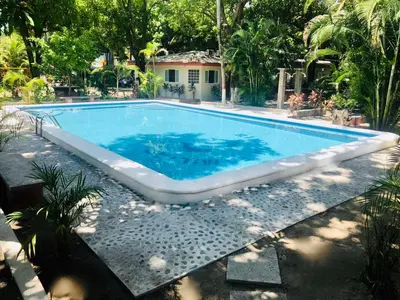 a large swimming pool with blue water in a yard at Hotel y Restaurante Rincón Familiar in La Libertad