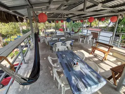a patio with a blue table and chairs and red lanterns at Hotel y Restaurante Rincón Familiar in La Libertad