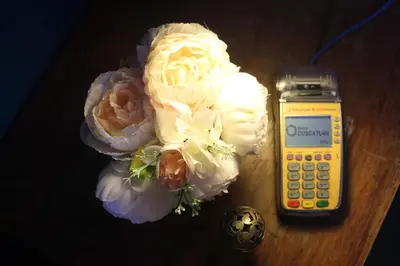 a calculator and flowers on a table next to a cell phone at Velvet hotel centro histórico in Santa Ana