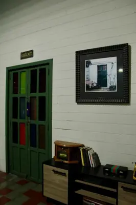a room with a green door and a dresser and a mirror at Velvet hotel centro histórico in Santa Ana