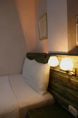 a bed with two lamps on top of it at Velvet hotel centro histórico in Santa Ana