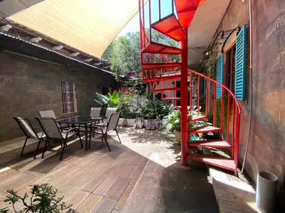 a patio with a red staircase and a table and chairs at Velvet hotel centro histórico in Santa Ana