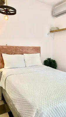 a bedroom with a large bed with white sheets at Velvet hotel centro histórico in Santa Ana