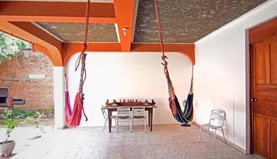 a room with a table and chairs and ropes hanging from the ceiling at Hotel Europa in San Miguel