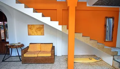 an orange room with a couch and a surfboard at Hotel Europa in San Miguel