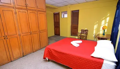 a bedroom with a red bed and wooden cabinets at Hotel Europa in San Miguel