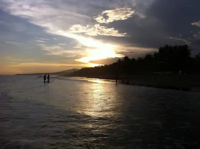 a group of people walking on the beach at sunset at Hotel Europa in San Miguel