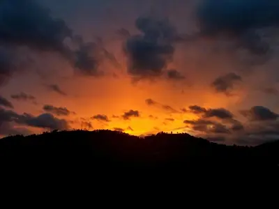 a sunset on top of a hill with a mountain at Hotel y Restaurante Las Margaritas in Perquín