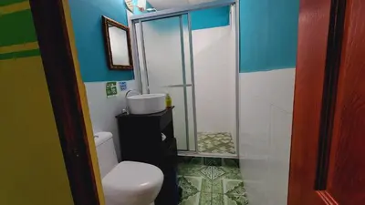 a bathroom with a toilet and a shower at Hotel y Restaurante Las Margaritas in Perquín