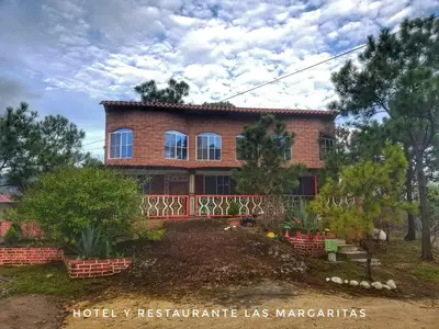a house in the middle of a yard at Hotel y Restaurante Las Margaritas in Perquín