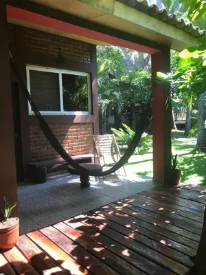 a hammock on the porch of a house at Hotel & Bar La Guitarra in El Sunzal