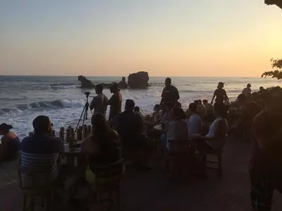 a group of people sitting on the beach watching the sunset at Hotel & Bar La Guitarra in El Sunzal