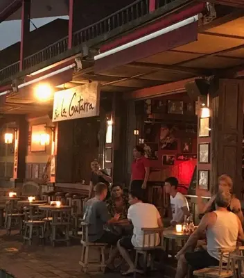 a group of people sitting at tables in a restaurant at Hotel & Bar La Guitarra in El Sunzal