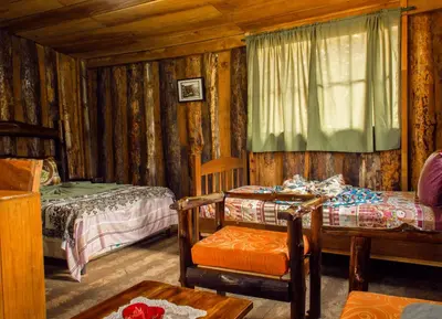 a bedroom with two beds and a table and a chair at Alla Arriba in Las Cruces