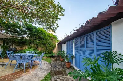 a patio with a table and chairs next to a building at Hotel Casa Pino, Tu Casa en Ataco in Concepción de Ataco