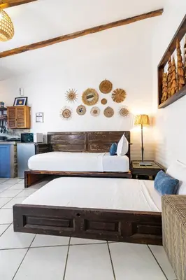 a bedroom with two beds and a couch at Hotel Casa Pino, Tu Casa en Ataco in Concepción de Ataco