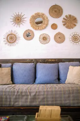 a couch against a wall with different types of hats at Hotel Casa Pino, Tu Casa en Ataco in Concepción de Ataco