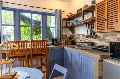 a kitchen with blue cabinets and a table with chairs at Hotel Casa Pino, Tu Casa en Ataco in Concepción de Ataco