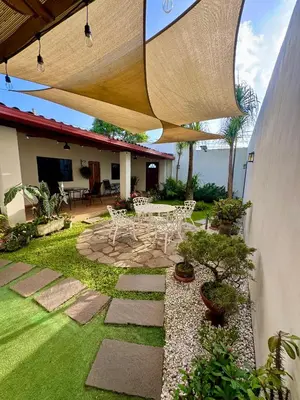 a patio with a table and chairs in a yard at Hostal DEYLUWIN in Juayúa