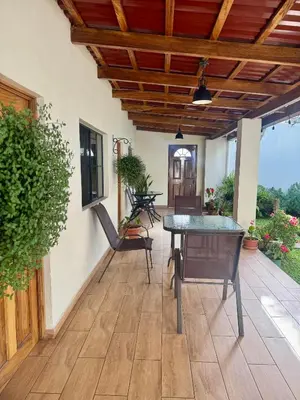 a patio with a table and chairs and a wooden ceiling at Hostal DEYLUWIN in Juayúa