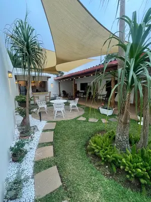 a patio with a table and chairs and palm trees at Hostal DEYLUWIN in Juayúa