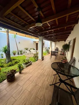 a patio with a glass table on a wooden floor at Hostal DEYLUWIN in Juayúa