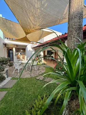 a patio with a table and chairs and a tree at Hostal DEYLUWIN in Juayúa