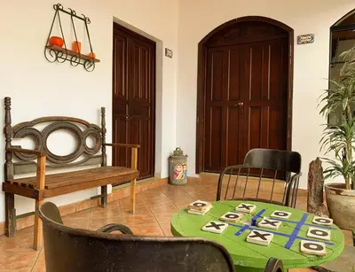 a room with a table and chairs and a bench at Hostal Las Puertas in Santa Ana