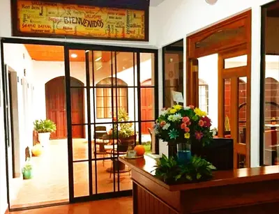 a restaurant with glass doors and flowers on a counter at Hostal Las Puertas in Santa Ana