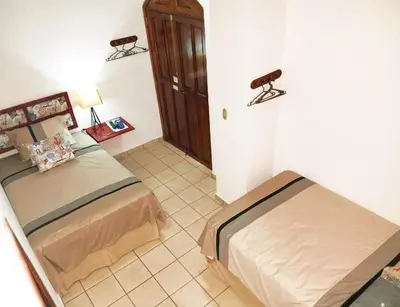 a bedroom with two beds in a room at Hostal Las Puertas in Santa Ana
