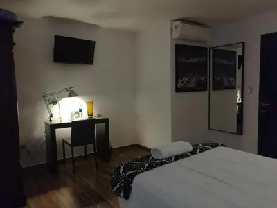 a bedroom with a bed and a desk with a lamp at Hotel Boutique Valverde Santa Elena in San Salvador
